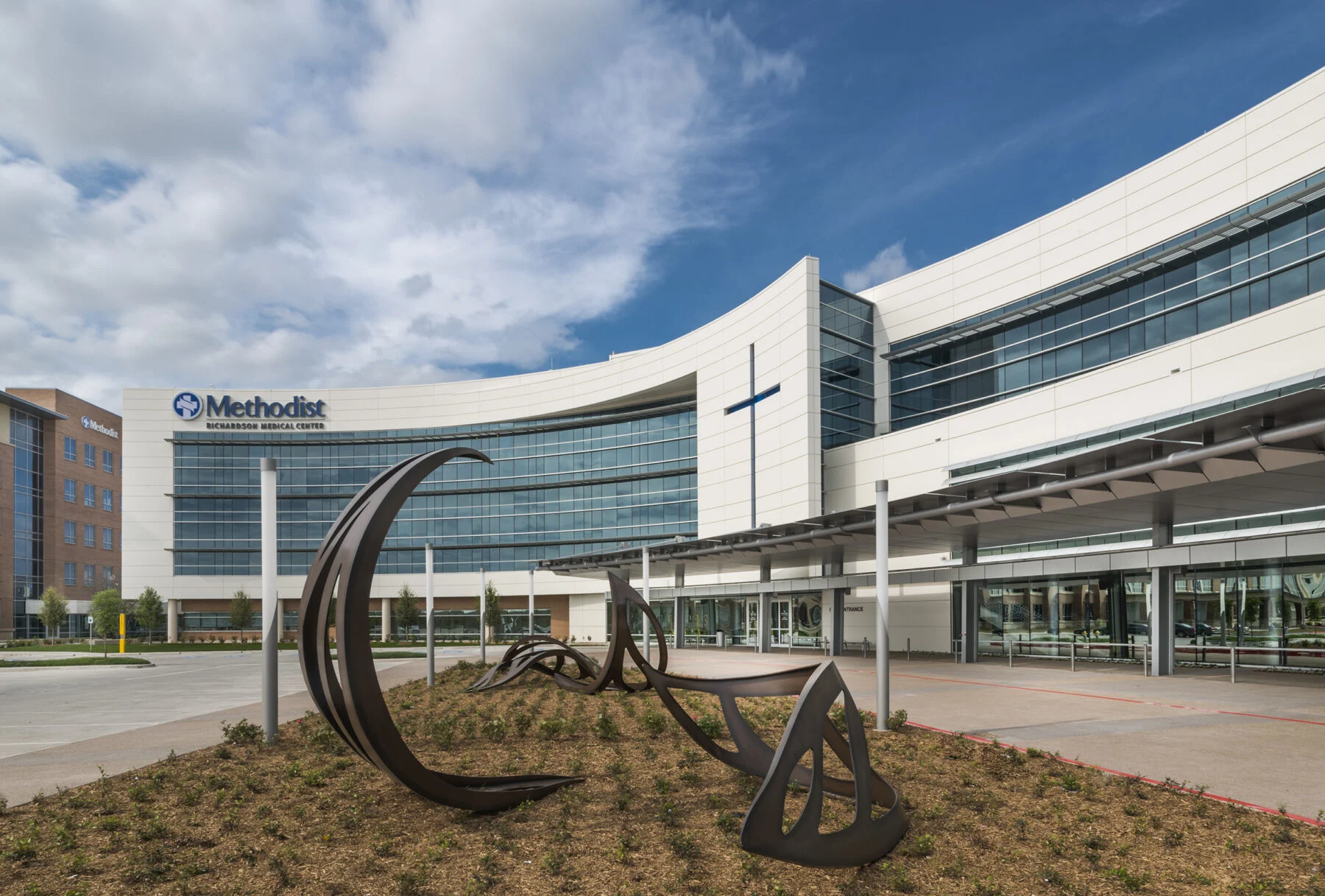 exterior of four story hospital with curved building and artistic elements