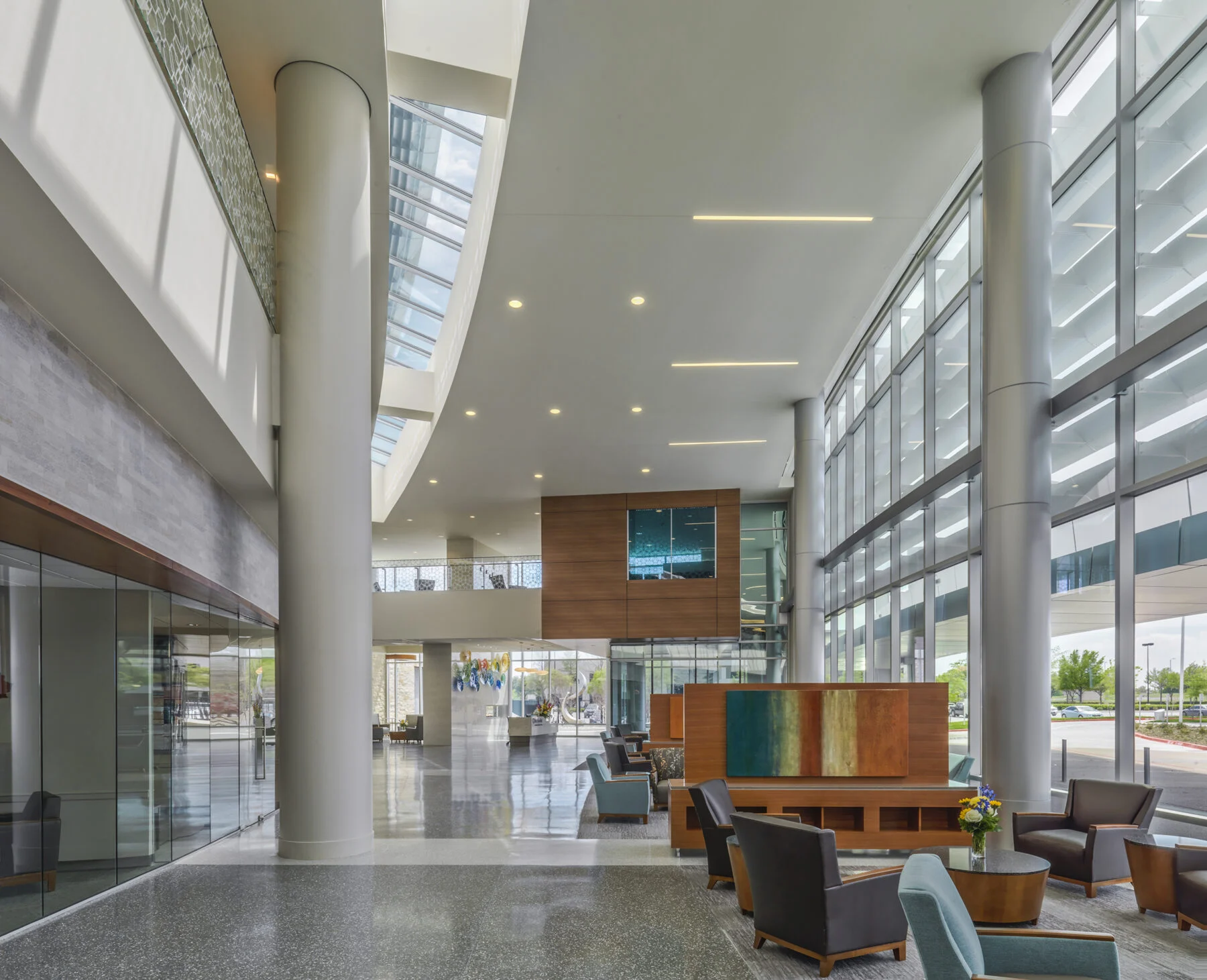 large open lobby space with exposed columns and floor to ceiling windows
