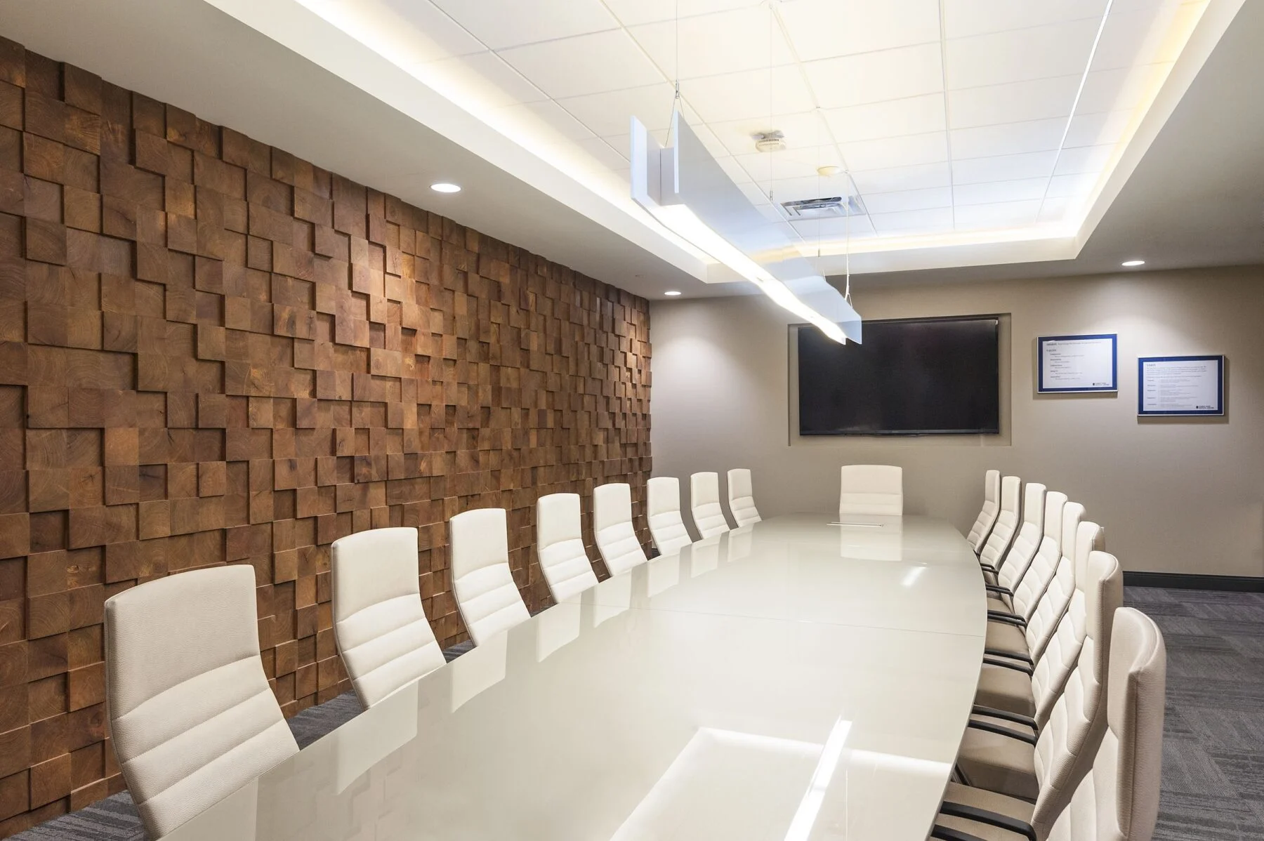 oval desk in a conference room and custom wood wall