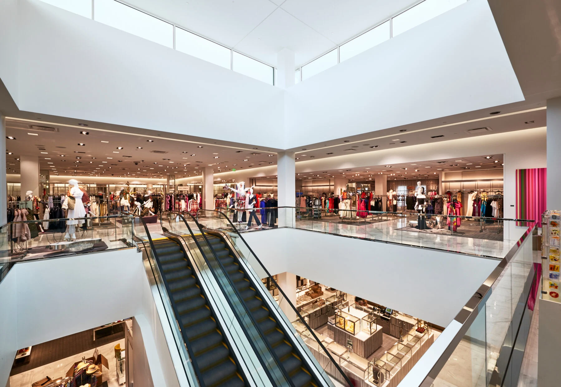 Two story view of retail space with clothing and escalator.