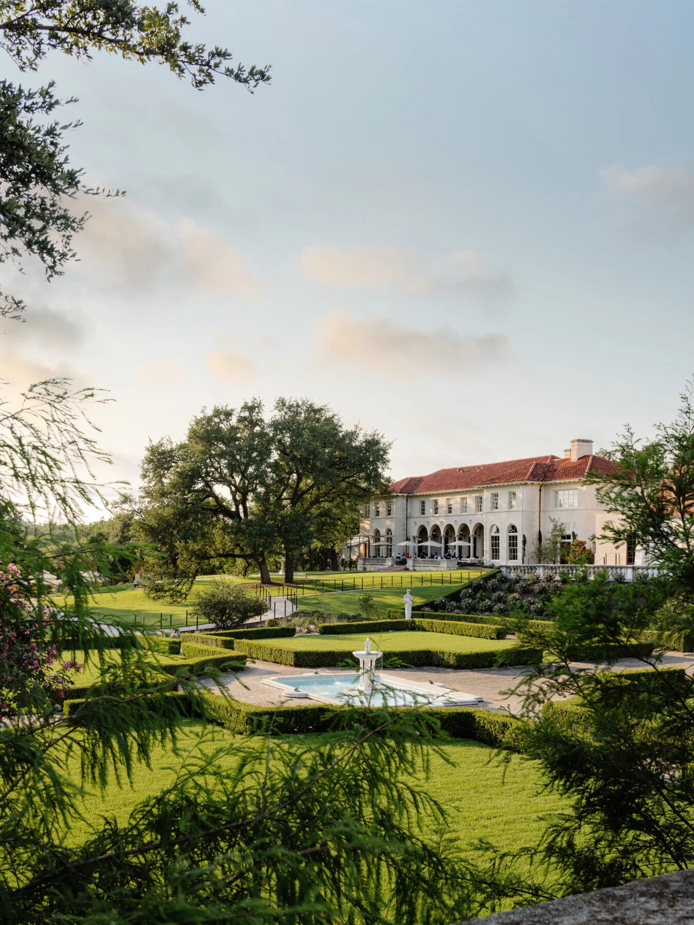 Landscaping with green gardens and fountains outside of the hotel.