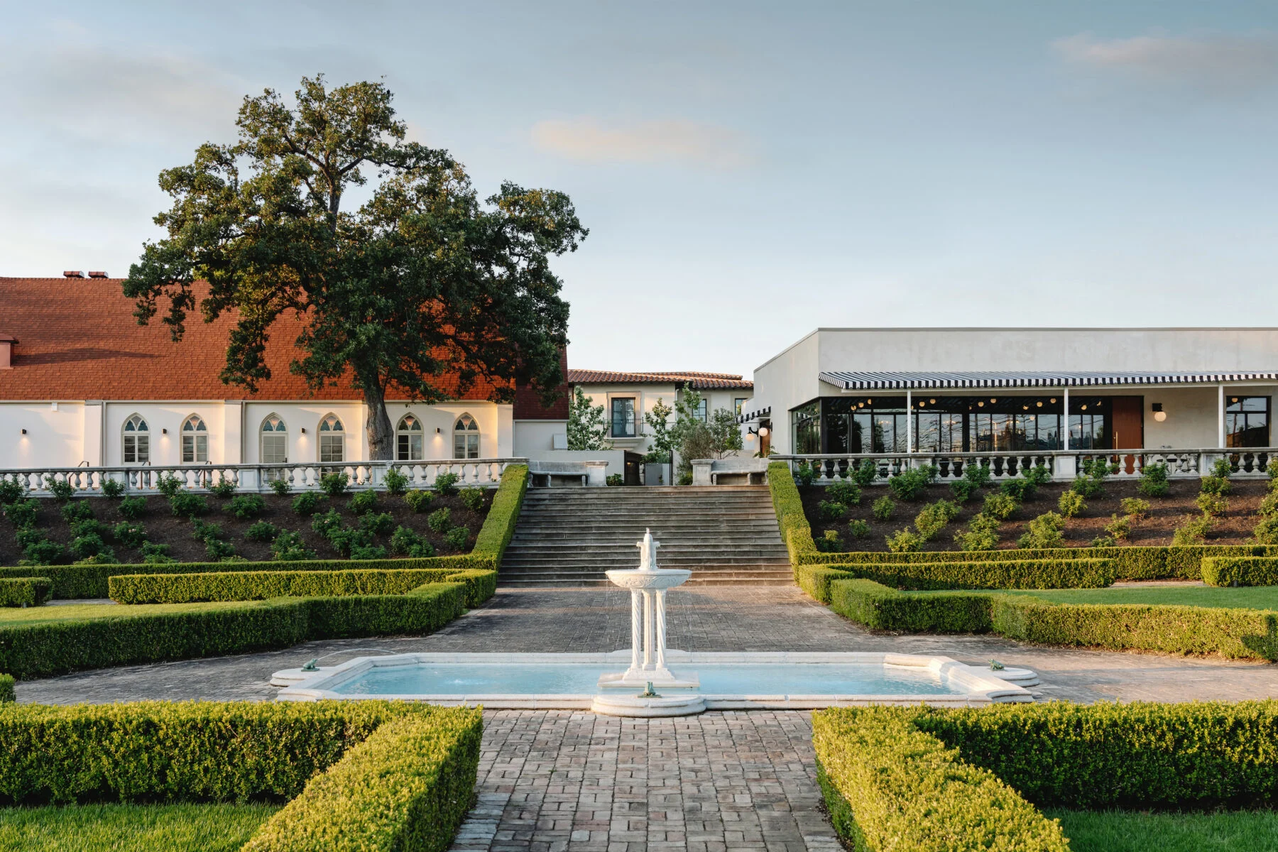 Landscaping with green gardens and fountains outside of the hotel.