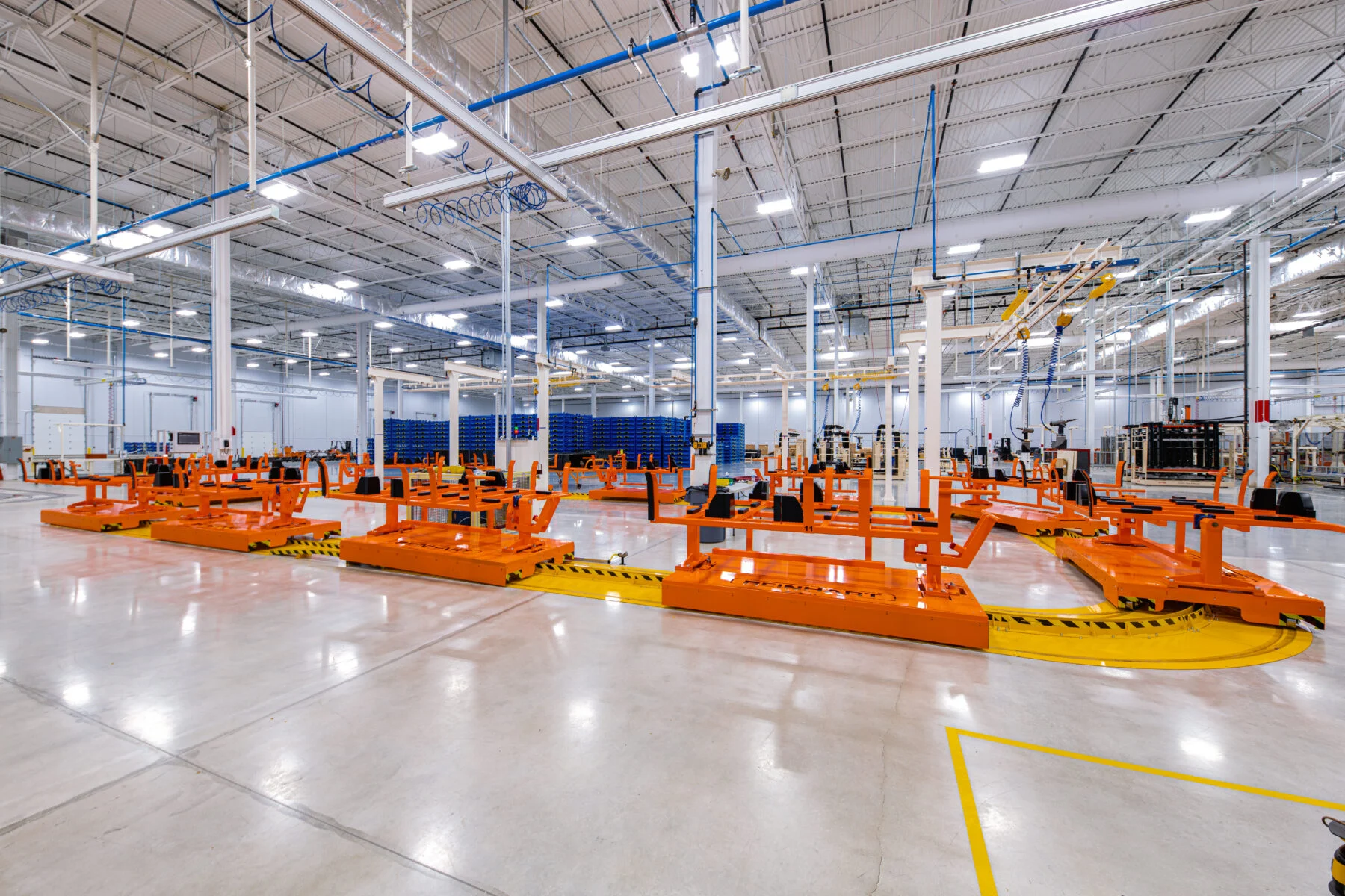 advanced manufacturing facility with wide open white space filled with orange equipment