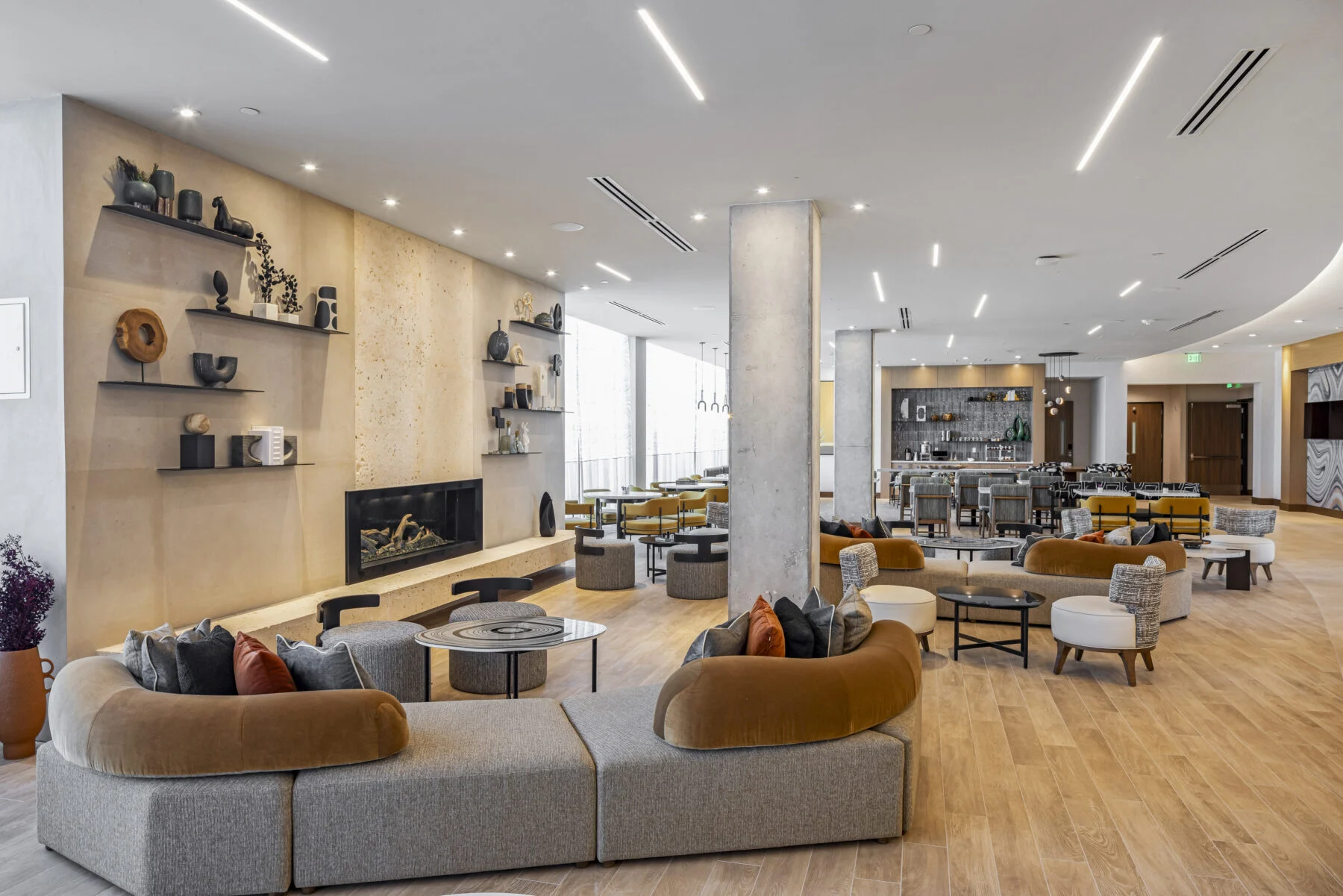 Lobby space with exposed columns and warm tones and seating for breakfast
