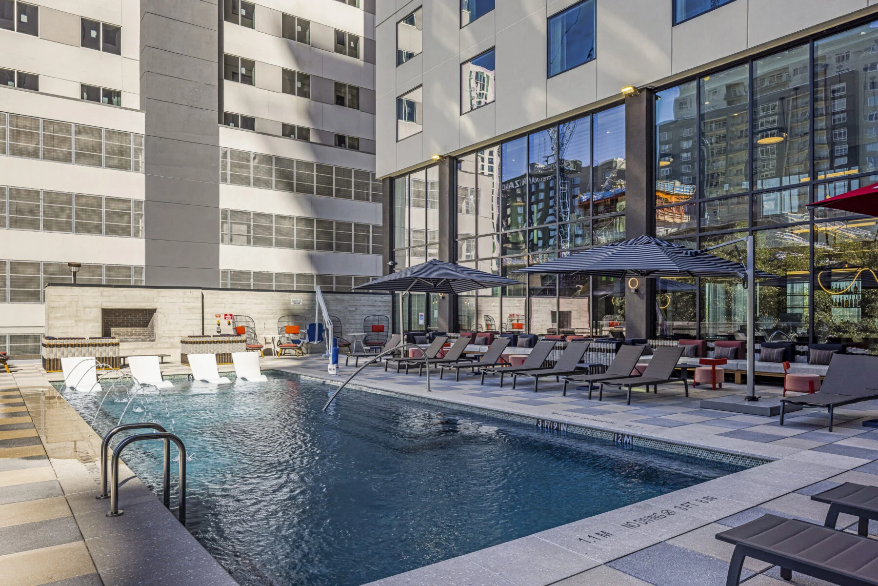 Rooftop pool with umbrellas and lounge chairs.