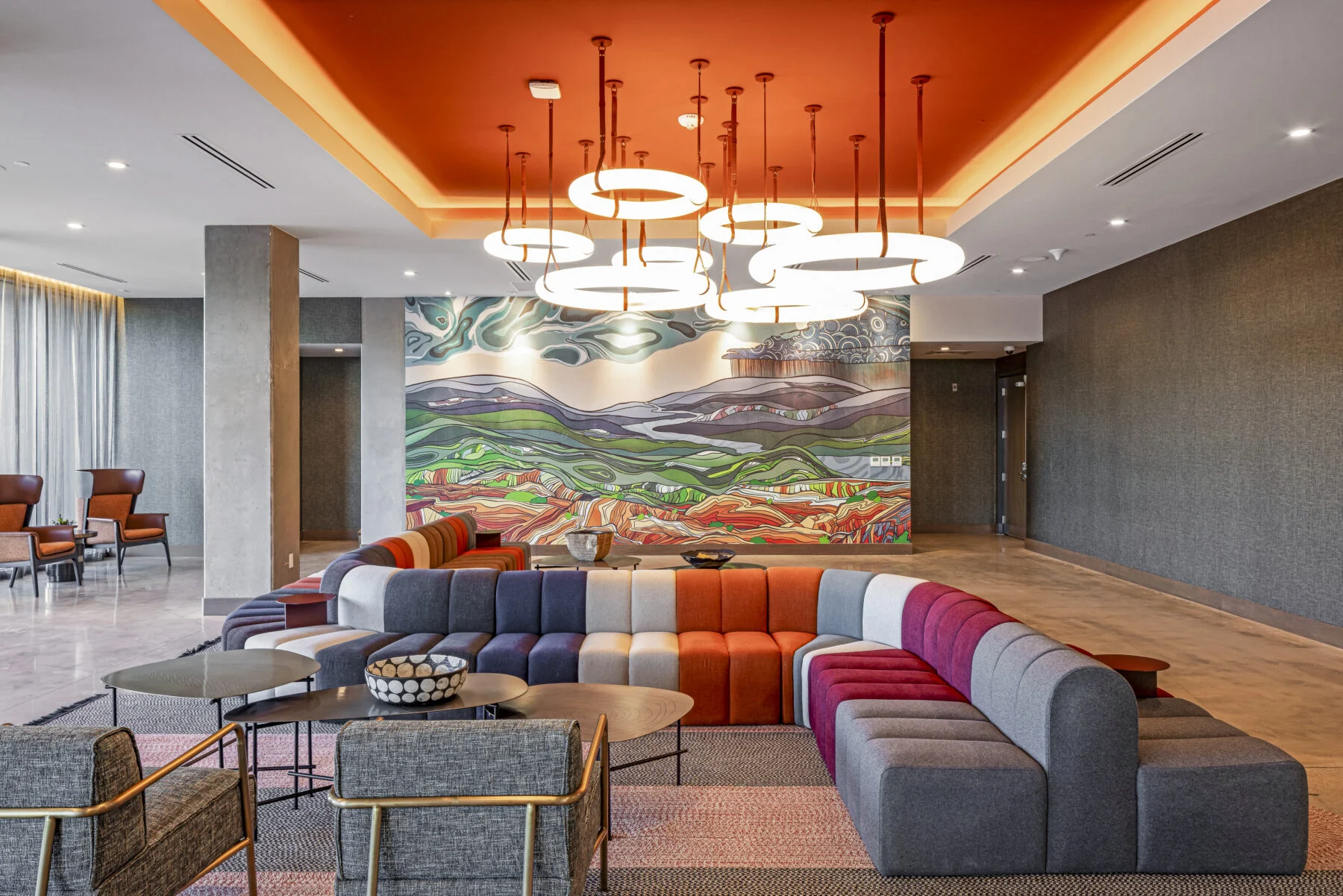 vibrant orange and pink hotel lobby lounge with unique lighting and art on walls