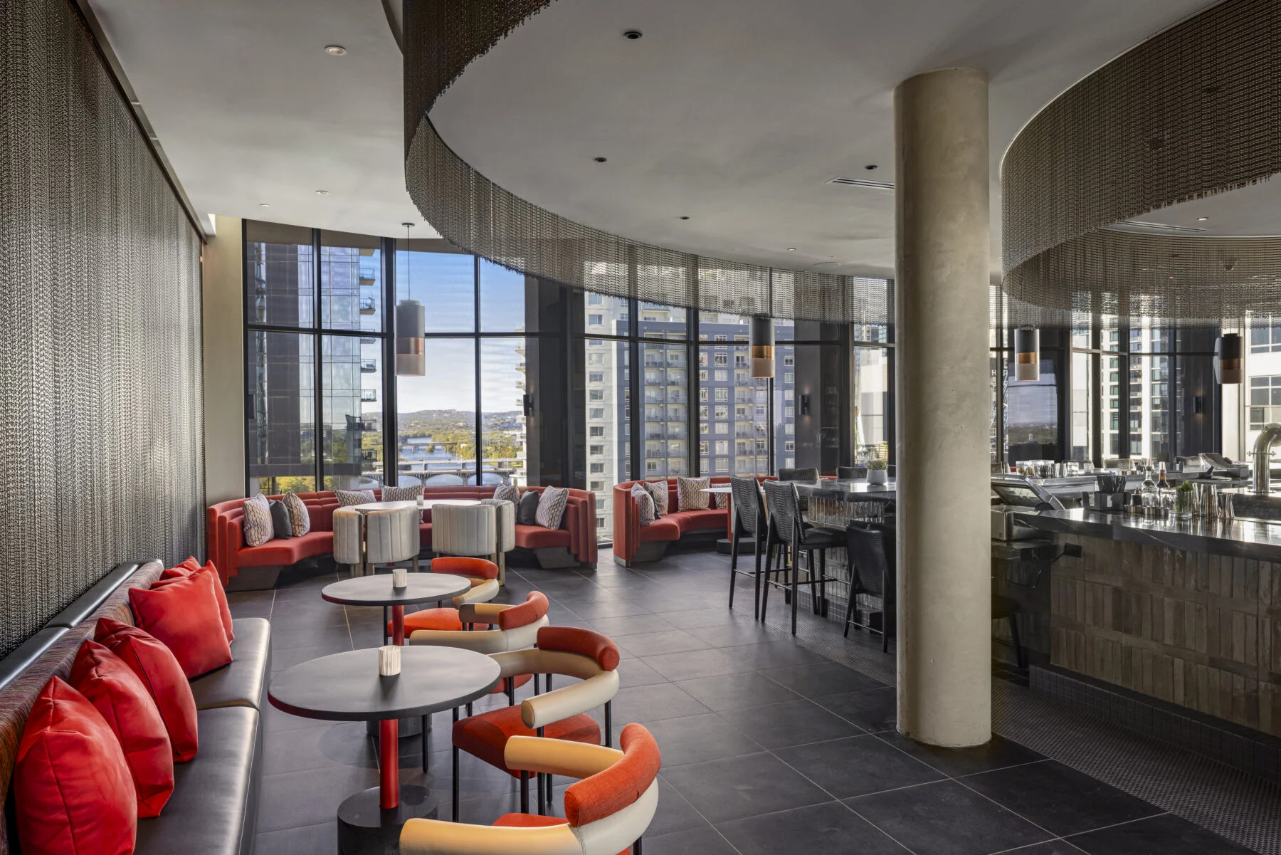 Bar with exposed concrete columns and curved architecture and views of Austin.