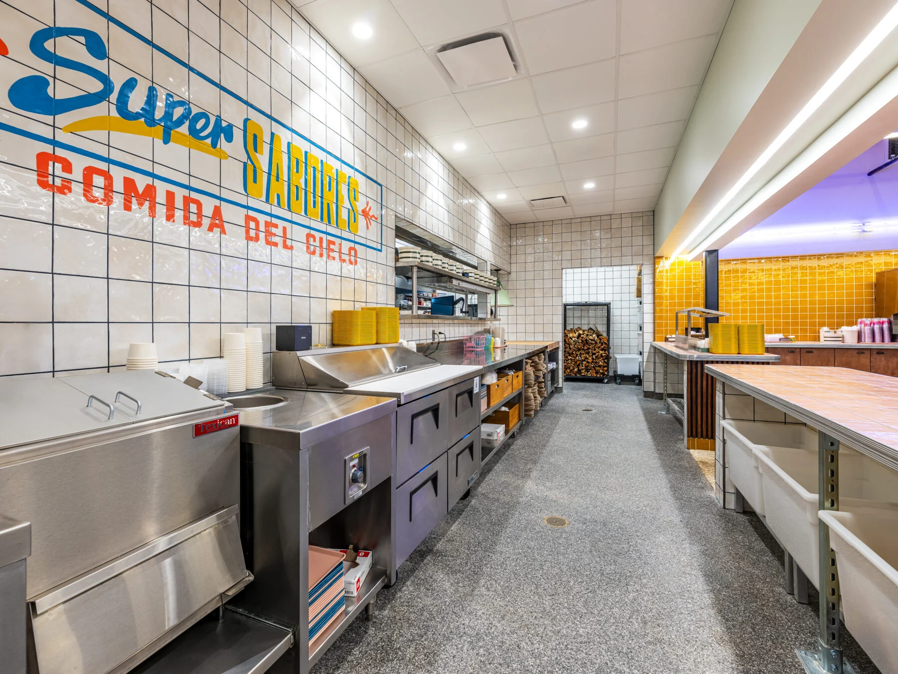 Commercial kitchen with colorful artwork on white tile
