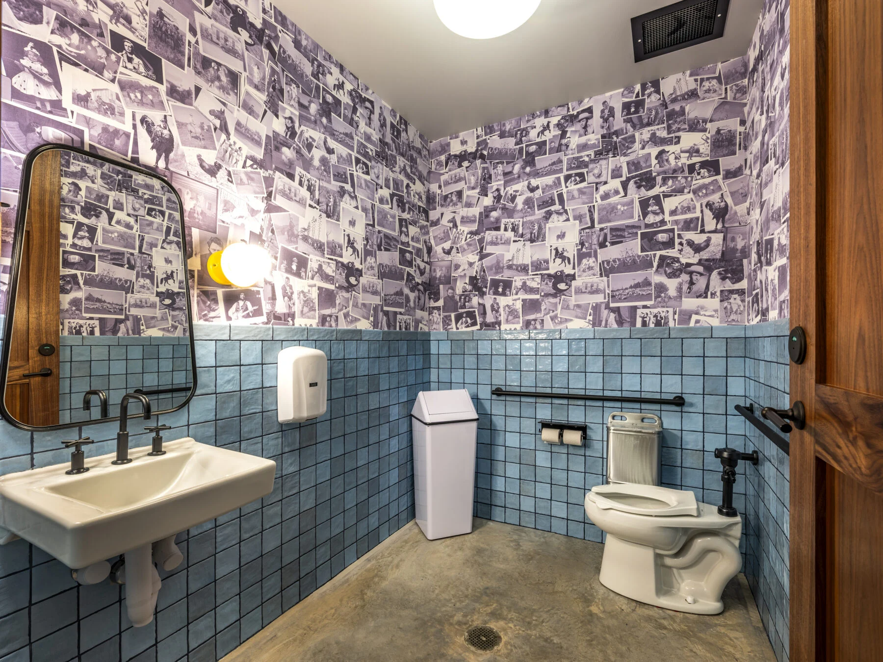 public restroom with blue tile and custom photo artwork wall paper
