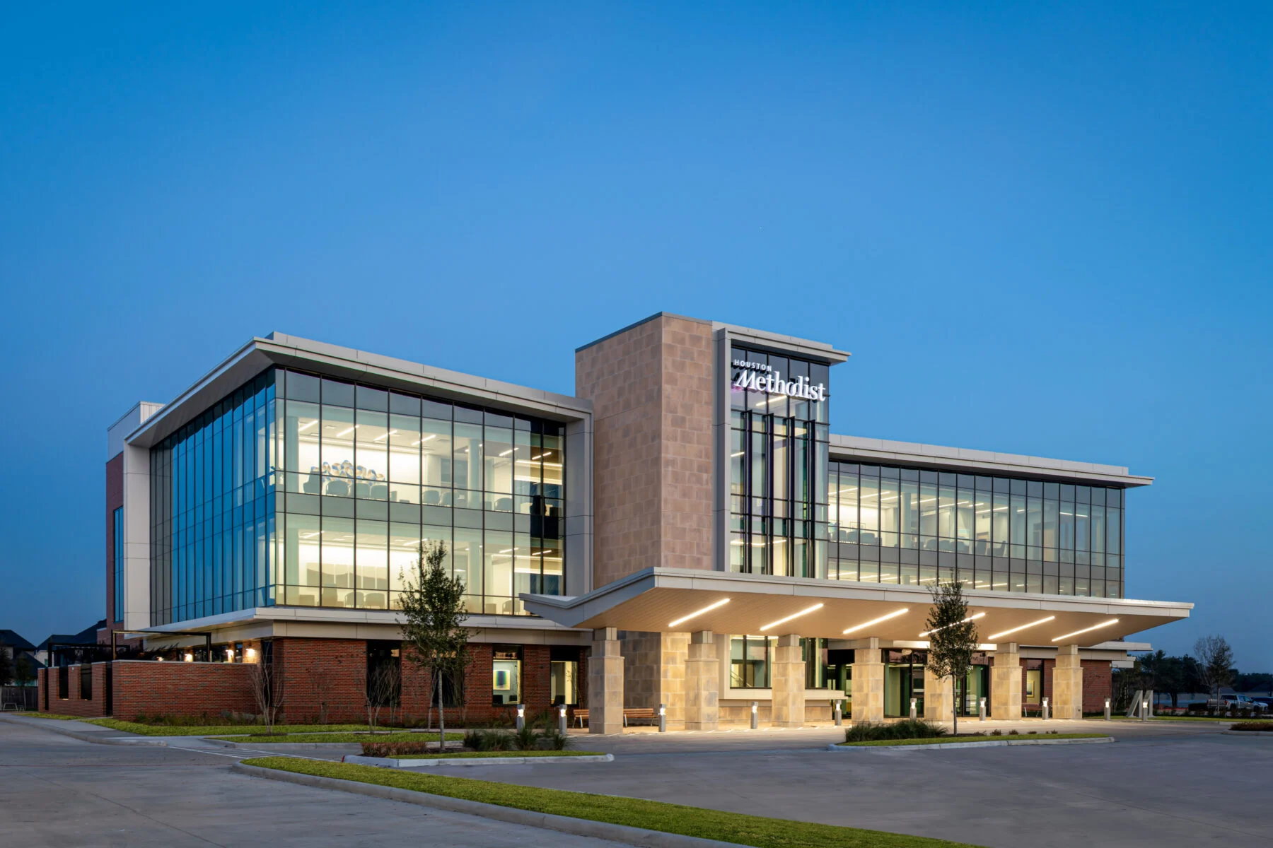 exterior of three story comprehensive care center with windows and custom lights