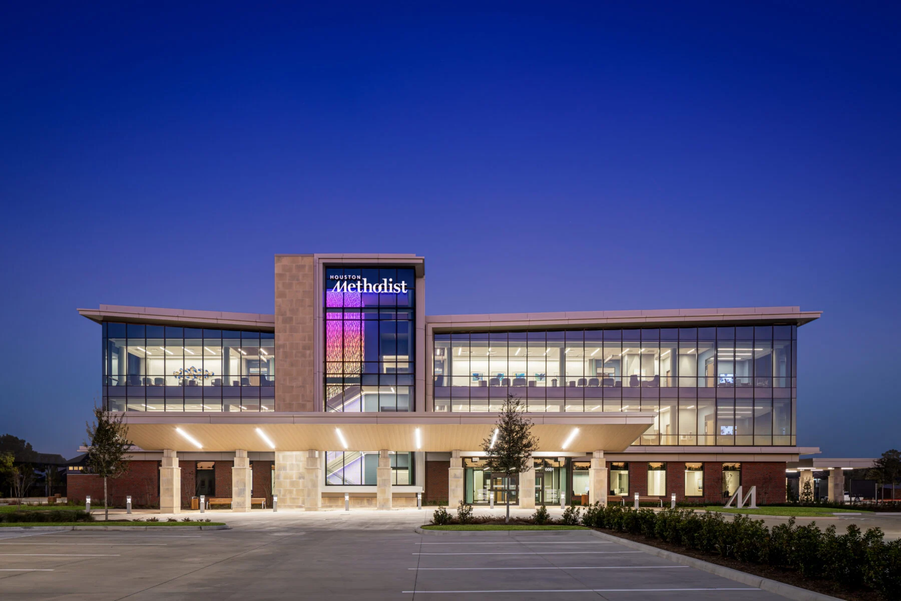 exterior of three story comprehensive care center with windows and custom lights