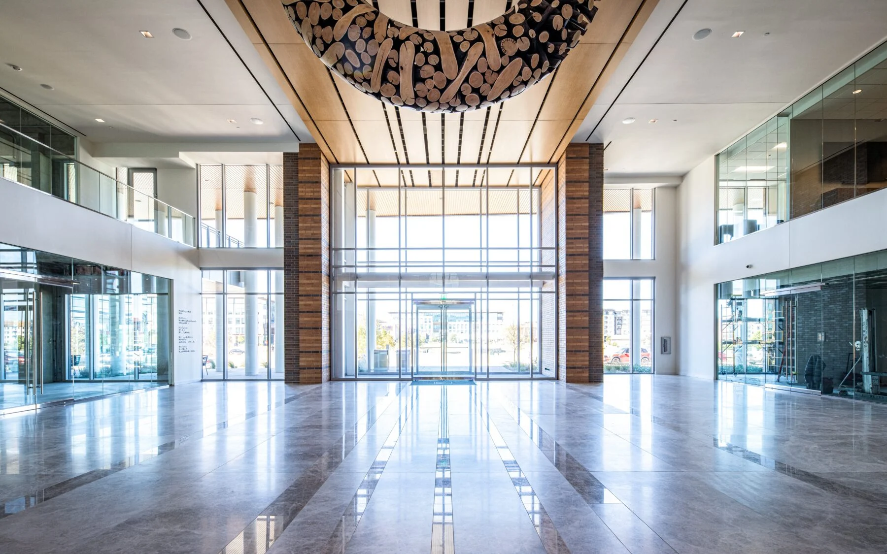 glass entry lobby with exposed columns and marble floors