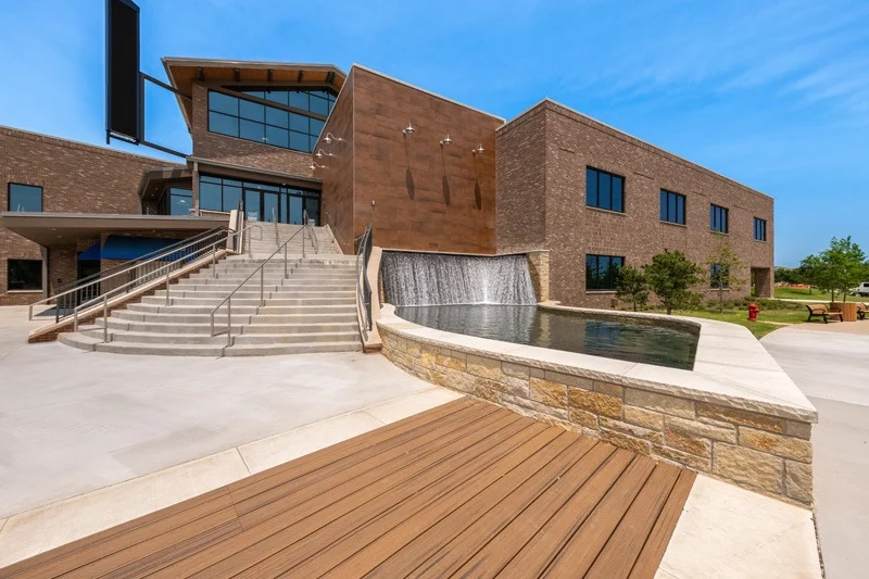 staircase and waterfall leading to two story brick building