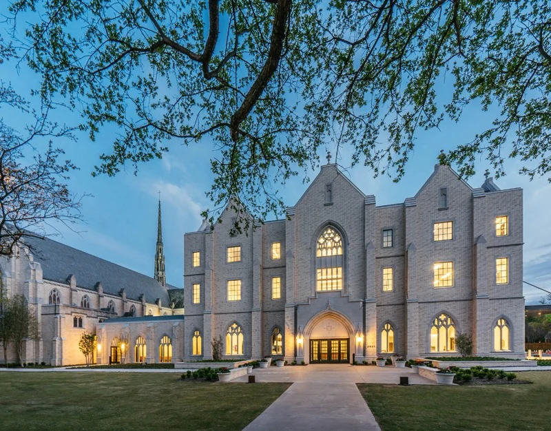three story stone church with warm lighting at night