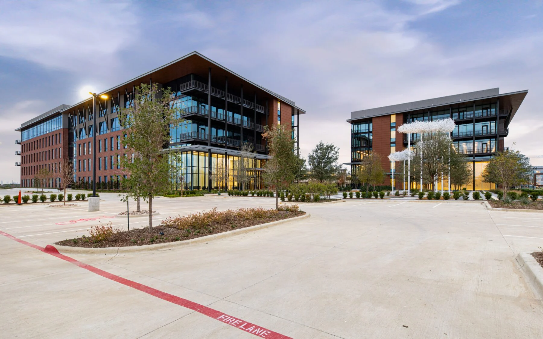 two modern five story buildings with glass and stone mason