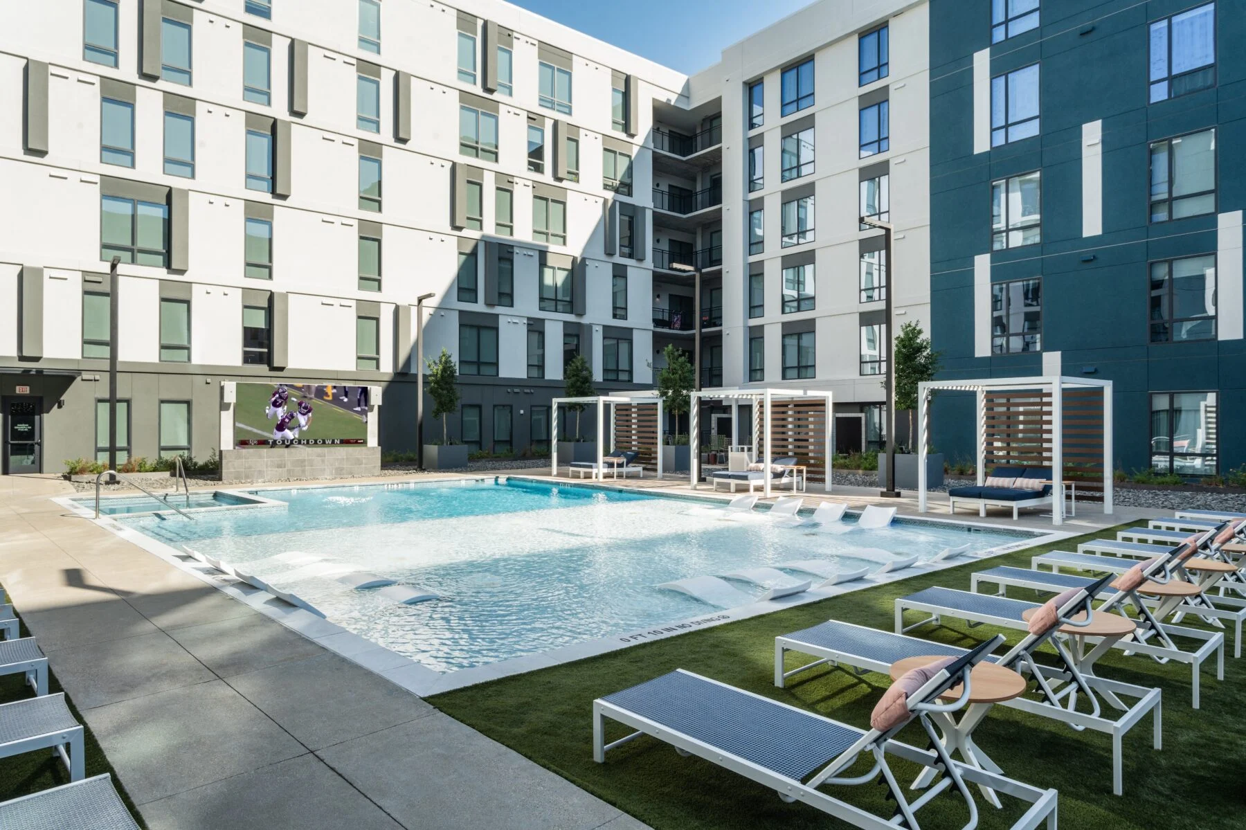 pool with turf lawn and cabanas